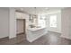 Modern white kitchen with stainless steel appliances, an island, and pendant lights at 4253 Millcroft Pl # 198, Buford, GA 30518
