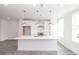Well-lit, open-concept kitchen boasts a spacious island, stainless steel appliances, white cabinetry, and pendant lighting at 4253 Millcroft Pl # 198, Buford, GA 30518