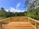 Beautiful new wooden deck overlooking green trees and foliage on a sunny day at 7252 Eton Ln, Locust Grove, GA 30248