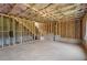 Large unfinished basement featuring framed walls, a stairwell, and poured concrete floors at 7252 Eton Ln, Locust Grove, GA 30248