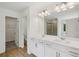 Well-lit bathroom featuring double sinks, a large mirror, and a shower at 7252 Eton Ln, Locust Grove, GA 30248