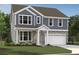 Charming two-story home showcasing stone accents, light blue siding, and a well-manicured lawn at 7252 Eton Ln, Locust Grove, GA 30248