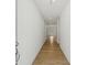 A bright hallway featuring wood flooring and white walls leading to other rooms in the home at 7252 Eton Ln, Locust Grove, GA 30248