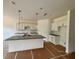 Modern kitchen featuring white cabinets, granite counters, and a large island with pendant lighting at 7252 Eton Ln, Locust Grove, GA 30248