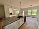 Kitchen island with dark granite countertop, white cabinets, and a view to the living area at 7252 Eton Ln, Locust Grove, GA 30248
