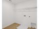 Practical laundry room with wood-look floors, washer/dryer hookups, and shelving at 7252 Eton Ln, Locust Grove, GA 30248