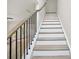 Carpeted staircase with decorative iron spindles at 7252 Eton Ln, Locust Grove, GA 30248