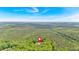 Expansive aerial view showcases the home's location amidst lush greenery with a neighborhood in the distance at 4332 Brushy Mountain Rd, Rockmart, GA 30153