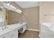 Bathroom with dual sinks, a large mirror, and a walk-in tub at 4332 Brushy Mountain Rd, Rockmart, GA 30153