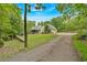 View of home on the lot featuring brick siding, green metal roof, and a long gravel driveway at 4332 Brushy Mountain Rd, Rockmart, GA 30153