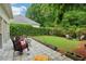 Spacious backyard featuring a stone patio, comfortable seating, and lush green landscaping at 979 Bridgegate Ne Dr, Marietta, GA 30068