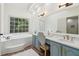 Bathroom featuring a stylish vanity, garden tub, and large window at 979 Bridgegate Ne Dr, Marietta, GA 30068