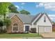 Charming home exterior with stone accents, a well-manicured lawn, and a two-car garage, offering great curb appeal at 979 Bridgegate Ne Dr, Marietta, GA 30068