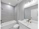 Bright bathroom with combination shower and tub, white cabinets, and modern fixtures at 2171 Burnside Dr Nw, Atlanta, GA 30318