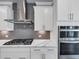 Gourmet kitchen with gas cooktop, modern backsplash, and stainless steel double ovens at 2171 Burnside Dr Nw, Atlanta, GA 30318