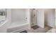 Bright bathroom featuring a bathtub, separate shower, and neutral decor at 2631 Lovejoy Crossing Dr, Hampton, GA 30228