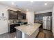 Modern kitchen with dark cabinets, granite counters, stainless steel appliances, and island at 2631 Lovejoy Crossing Dr, Hampton, GA 30228