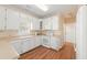 Kitchen features white cabinets and appliances with light countertops and tiled backsplash at 310 Autumn Glen Cir, Fayetteville, GA 30215