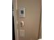 A thermostat is mounted to a wall with a switch and ceiling fan remote below at 3978 Devonshire Dr, Marietta, GA 30066