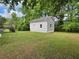 View of backyard of property showcasing trimmed lawn and a one car garage with two windows at 53 Villa Rosa Way, Temple, GA 30179