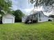 View of the home's back exterior featuring a wooden deck, lawn and a detached garage at 53 Villa Rosa Way, Temple, GA 30179