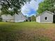 View of backyard with home and detached one car garage and deck at 53 Villa Rosa Way, Temple, GA 30179
