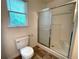 Bathroom featuring a toilet, window with blinds, and shower with sliding door at 53 Villa Rosa Way, Temple, GA 30179
