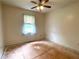 A bedroom with a window, ceiling fan, and unfinished flooring at 53 Villa Rosa Way, Temple, GA 30179