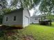 View of the home's back exterior featuring a wooden deck, lawn and a detached garage at 53 Villa Rosa Way, Temple, GA 30179