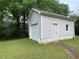 View of backyard of property showcasing trimmed lawn and a one car garage at 53 Villa Rosa Way, Temple, GA 30179
