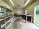 View of the garage featuring ceiling lights, a fan, shelving, windows, and work benches at 53 Villa Rosa Way, Temple, GA 30179