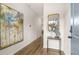 Well-lit hallway with wood floors featuring modern art and an accent table with mirror at 9452 Pinecrest Path # 314, Jonesboro, GA 30238