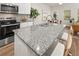 Close up view of the kitchen island featuring granite countertops, barstool seating, and stainless appliances at 9452 Pinecrest Path # 314, Jonesboro, GA 30238