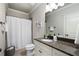 Neutral bathroom has granite counters and vanity with white shower curtain and decor at 1165 Victoria Ne St, Brookhaven, GA 30319