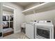 Bright laundry room features front-load washer/dryer and built-in shelving, adjacent to a walk-in closet at 1165 Victoria Ne St, Brookhaven, GA 30319