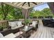 Relax on this cozy covered patio with fan, curtains, and serene backyard views at 1165 Victoria Ne St, Brookhaven, GA 30319