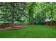 This backyard features a lush lawn, several mature trees, and a fence at 1349 Middlesex Ne Ave, Atlanta, GA 30306