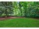 This backyard features a lush lawn, several mature trees, and a fence at 1349 Middlesex Ne Ave, Atlanta, GA 30306