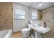 Cozy bathroom with beige tile, a pedestal sink, large mirror, and a bathtub at 1349 Middlesex Ne Ave, Atlanta, GA 30306