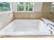 Large soaking bathtub with tiled surround and a view of the outside, perfect for relaxation at 1349 Middlesex Ne Ave, Atlanta, GA 30306