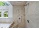 This shower features tiled walls, an adjustable shower head, and a window with a green view at 1349 Middlesex Ne Ave, Atlanta, GA 30306