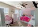 Bedroom featuring a white canopy bed, a pink desk and chair, and neutral walls and carpet at 2267 Clapton Ct, Jonesboro, GA 30236