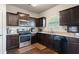 Galley kitchen featuring granite countertops, stainless appliances and dark wood cabinets at 2267 Clapton Ct, Jonesboro, GA 30236