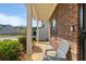 Inviting covered porch with a chair, brick pillars, and manicured greenery at 2267 Clapton Ct, Jonesboro, GA 30236