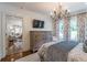 Bright bedroom with windows and decorative curtains, featuring a rustic wooden dresser and chandelier at 2406 Glenwood Ne Dr, Atlanta, GA 30305