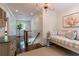 Bright hallway with daybed, artwork, and hardwood floors leading to the staircase at 2406 Glenwood Ne Dr, Atlanta, GA 30305