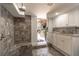 Shower with stone-look tile and bench with a view of an outdoor bar and kitchen area at 2406 Glenwood Ne Dr, Atlanta, GA 30305