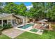 Entertainer's backyard featuring a sparkling pool, multiple seating areas, and lush landscaping at 5785 Timberlane Ter, Sandy Springs, GA 30328