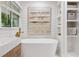 Bright bathroom features a soaking tub, natural light, wood accents, and built in storage shelves at 5785 Timberlane Ter, Sandy Springs, GA 30328