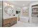 Bright bathroom features a soaking tub, modern vanity, and a large round mirror at 5785 Timberlane Ter, Sandy Springs, GA 30328